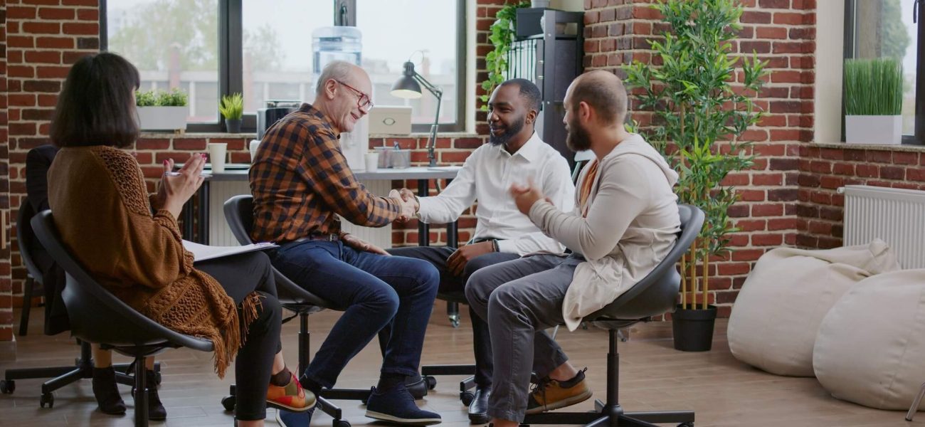 A group of four adults sitting and talking