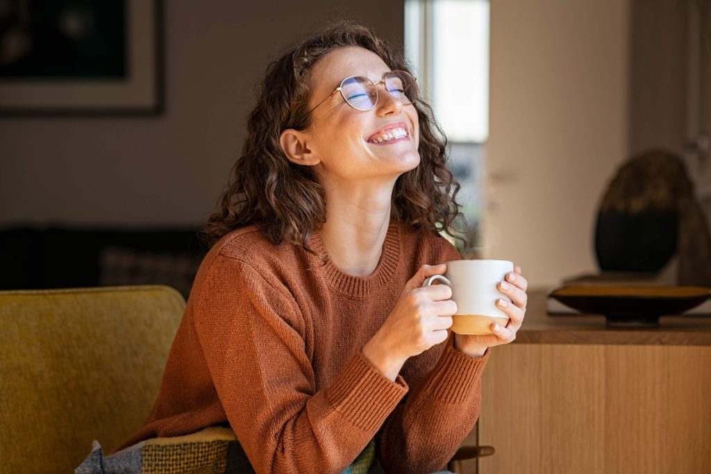 A smiling woman holding a cup of tea