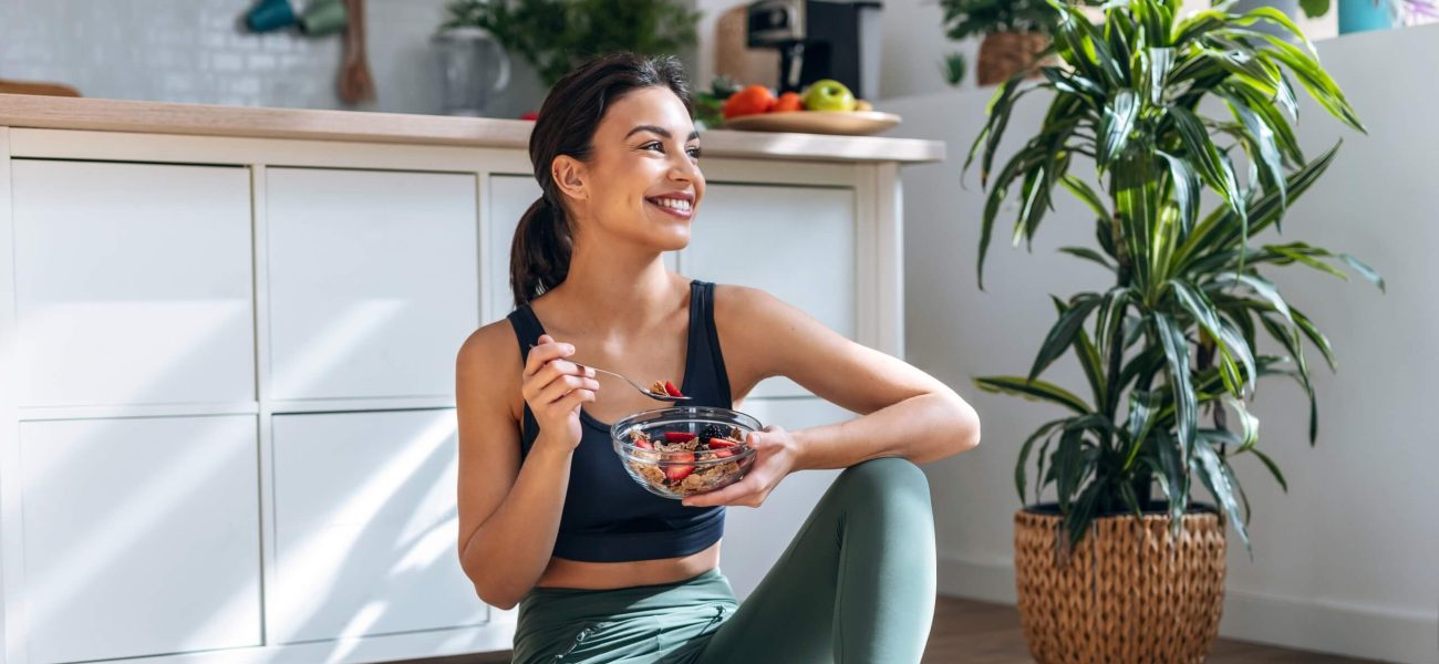 A form eating a healthy breakfast in fitness clothes