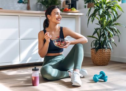 A form eating a healthy breakfast in fitness clothes